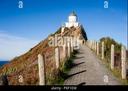 Nugget Point Lighthouse, Catlins Coast, Neuseeland. Atemberaubende Szene, sonnige, Vordergrund, tiefblaue Meer und Himmel Stockfoto