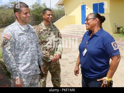 Kapitän Signalda Olario (links), einen älteren Führer in der Freiwilligenorganisation Curacao (VKC), grüßt Kapitän J.R. Wiggins (Mitte) und Maj. David Tavares (links), der Florida Army National Guard (FLARNG). Mitglieder aus dem FLARNG kam in Curacao einen Informationsaustausch mit der Vkc auf Best Practices, die auf der Suche und Rettung konzentrieren, die die Unterstützung und medizinische Antwort Taktik, 30. Juli 2018. Stockfoto