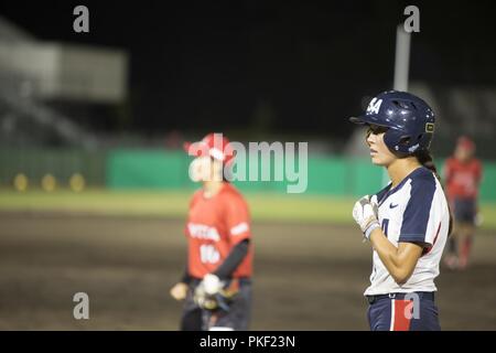 Janie Reed, rechts, ein outfielder mit Nationalmannschaft der USA Softball Frauen, steht in Position, während Sie in einem Softball Spiel gegen die japanischen Toyota Red Terrier Softballmannschaft in Stadt Iwakuni, Japan, 31. Juli 2018 zu konkurrieren. Das US-Team besuchte Marine Corps Air Station Iwakuni und Iwakuni Stadt, um für die World Baseball Softball Eidgenossenschaft (WBSC) Weltmeisterschaft der Frauen, wo sie geplant sind für einen Platz in der Olympischen Spiele 2020 in Tokio, Japan zu konkurrieren. Stockfoto