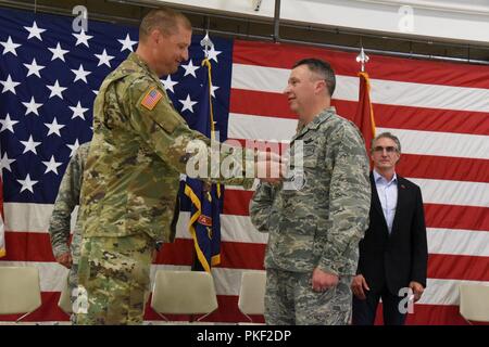 Generalmajor Al Dohrmann, der North Dakota Adjutant General, Orte der Bundesrepublik Legion der Verdienst Medaille auf der Uniform der Col. Britt Hatley bei einem Befehl Zeremonie Einführung Oberst Darrin Anderson als der neue 119 Wing Commander, mit Hatley, die Commander am North Dakota Air National Guard Base, Fargo, N.D., Aug 4, 2018. Stockfoto