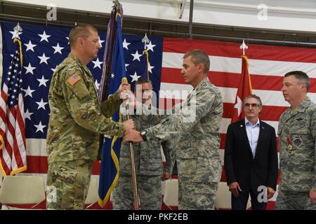 Generalmajor Al Dohrmann, der North Dakota Adjutant General, Links, präsentiert die 119 Flügel Einheit Flagge guidon zu oberst Darrin Anderson in einer symbolischen Geste mit der Flagge, die die organisatorischen das Kommando über die 119 Wing an der Texas Air National Guard Base, Fargo, N.D., Aug 4, 2018. Anderson ist Austausch gehen 119 Wing Commander Col. Britt Hatley, ganz rechts, wer hat die 119 Wing Commander seit Februar 4, 2017. Stockfoto