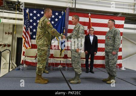 Generalmajor Al Dohrmann, der North Dakota Adjutant General, Links, gratuliert Oberst Darrin Anderson bei einem Befehl Zeremonie am North Dakota Air National Guard Base, Fargo, N.D., Aug 4, 2018. Anderson ist Austausch Col. Britt Hatley, weit Recht, die 119 Wing Commander. Stockfoto