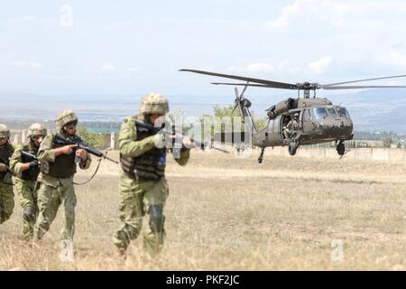 Ein Georgia Army National Guard UH-60 Black Hawk von Marietta, 1st Bataillon, 171St Aviation Regiment, hebt sich rasch nach dem Einlegen georgische Spezialeinheiten in einem städtischen Betrieb Übung in der wasiani Ausbildung Bereich auf Aug 5, 2018 während der Noble Partner 18. Die Übung verdeutlicht die 24 Jahre die beiden Armeen zusammen unter der US-Nationalgarde Partnerschaft Programm gearbeitet haben. Us-Armee Stockfoto