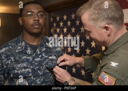 NEWPORT NEWS, Virginia (Aug 2, 2018) Yeoman 2. Klasse Sebastian Hudson, aus Raleigh, North Carolina, zu USS Gerald R. Ford's (CVN 78) Abteilung Verwaltung zugewiesen wird, erhält er den Soldaten Air Warfare Spezialist Stift von Kapitän Richard McCormack, Ford's kommandierenden Offizier, in der In-port Kabine. Stockfoto