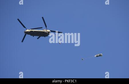 Ein U.S. Army CH-47 Chinook Hubschrauber, Bravo Company, 2-104 th GSAB, 28 Combat Aviation Brigade zugeordnet, fällt eine Gruppe von Fallschirmjägern auf Schloss Drop Zone bei Leapfest 2018 West Kingston, RI., 5. August 2018. Leapfest ist der größte und am längsten bestehende, internationale statische Linie Fallschirm Training und Wettbewerb veranstaltet vom 56. Truppe den Befehl, Rhode-Island Army National Guard hohe technische Ausbildung zu fördern und Korpsgeist innerhalb der internationalen Gemeinschaft in der Luft. Stockfoto