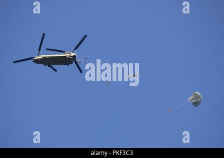 Ein U.S. Army CH-47 Chinook Hubschrauber, Bravo Company, 2-104 th GSAB, 28 Combat Aviation Brigade zugeordnet, fällt eine Gruppe von Fallschirmjägern auf Schloss Drop Zone bei Leapfest 2018 West Kingston, RI., 5. August 2018. Leapfest ist der größte und am längsten bestehende, internationale statische Linie Fallschirm Training und Wettbewerb veranstaltet vom 56. Truppe den Befehl, Rhode-Island Army National Guard hohe technische Ausbildung zu fördern und Korpsgeist innerhalb der internationalen Gemeinschaft in der Luft. Stockfoto