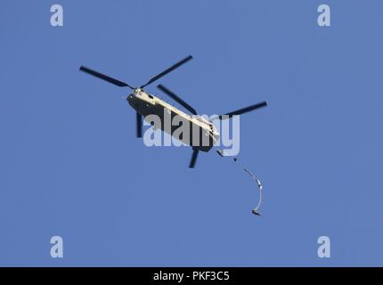 Ein U.S. Army CH-47 Chinook Hubschrauber, Bravo Company, 2-104 th GSAB, 28 Combat Aviation Brigade zugeordnet, fällt eine Gruppe von Fallschirmjägern auf Schloss Drop Zone bei Leapfest 2018 West Kingston, RI., 5. August 2018. Leapfest ist der größte und am längsten bestehende, internationale statische Linie Fallschirm Training und Wettbewerb veranstaltet vom 56. Truppe den Befehl, Rhode-Island Army National Guard hohe technische Ausbildung zu fördern und Korpsgeist innerhalb der internationalen Gemeinschaft in der Luft. Stockfoto