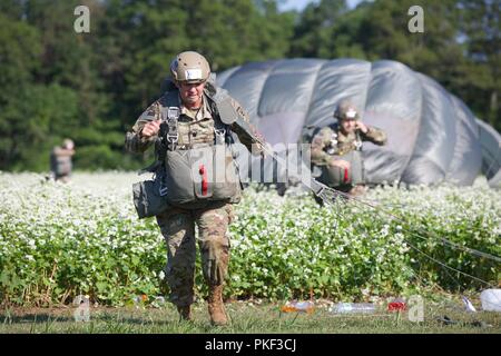 Zwei US-Armee Fallschirmjäger laufen in Richtung der X mit Ihrem MC-6 Fallschirme auf Schloss Drop Zone bei Leapfest 2018 West Kingston, RI., 5. August 2018. Leapfest ist der größte und am längsten bestehende, internationale statische Linie Fallschirm Training und Wettbewerb veranstaltet vom 56. Truppe den Befehl, Rhode-Island Army National Guard hohe technische Ausbildung zu fördern und Korpsgeist innerhalb der internationalen Gemeinschaft in der Luft. Stockfoto