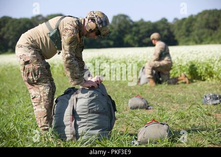 Zwei US-Armee Fallschirmjäger pack Ihre MC-6 Fallschirme nach Abschluss eines in die Luft springen Sie auf Schloss Drop Zone bei Leapfest 2018 West Kingston, RI., 5. August 2018. Leapfest ist der größte und am längsten bestehende, internationale statische Linie Fallschirm Training und Wettbewerb veranstaltet vom 56. Truppe den Befehl, Rhode-Island Army National Guard hohe technische Ausbildung zu fördern und Korpsgeist innerhalb der internationalen Gemeinschaft in der Luft. Stockfoto