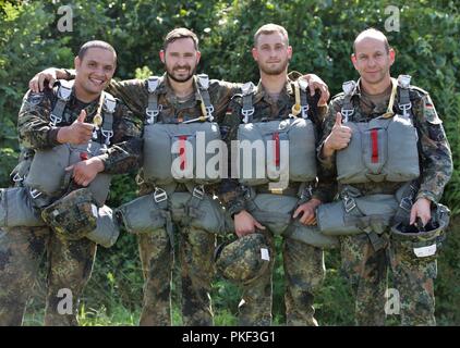 Eine Gruppe deutscher Fallschirmjäger posieren für ein Foto auf dem Pick Up Zone während Leapfest 2018 West Kingston, RI., 5. August 2018. Leapfest ist der größte und am längsten bestehende, internationale statische Linie Fallschirm Training und Wettbewerb veranstaltet vom 56. Truppe den Befehl, Rhode-Island Army National Guard hohe technische Ausbildung zu fördern und Korpsgeist innerhalb der internationalen Gemeinschaft in der Luft. Stockfoto