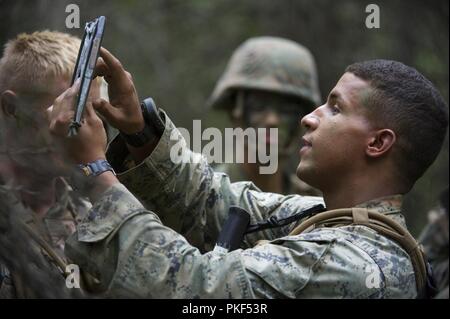 Us Marine Corps Sgt. James Ellis, Vordergrund, 3 Truppführer, 3 Bataillon, 23 Marine Regiment, geht über die Mission Plan mit seinem Marines während in der 4. Marine Division Super Squad Wettbewerb im Joint Base Elmendorf-Richardson, Alaska, Aug 4, 2018 konkurrieren. Während des Wettbewerbs, Gruppen von 1. und 3 Bataillonen, 23 Marine Regiment und 1 Bataillon, 24 Marine Regiment, übte ihre technischen und taktischen Fertigkeiten durch konkurrierende in Veranstaltungen, offensive/defensive Operationen hervorgehoben, patrouillieren Techniken, die Bekämpfung der Treffsicherheit, körperliche Ausdauer ein Stockfoto