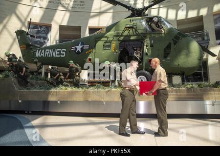 Us Marine Corps Maj. Jonathan Zarling, Links, stellvertretender Leiter, Manpower Management Soldaten Zuordnung (MMEA), stellt Zertifikate Master Gunnery Sgt. Cody Abel, Monitor, MMEA, an dem Nationalen Museum der Marine Corps, Dreieck, Virginia, 27. Juli 2018. Abel diente 20 Jahre Damen und Gläubigen der Wehrdienst. Stockfoto