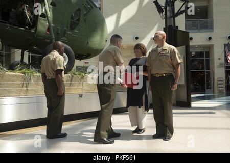 Us Marine Corps Maj. Jonathan Zarling, stellvertretender Leiter, Manpower Management Soldaten Zuordnung (MMEA), präsentiert eine Bescheinigung der Anerkennung an die Frau von Master Gunnery Sgt. Cody Abel, Monitor, MMEA, an dem Nationalen Museum der Marine Corps, Dreieck, Virginia, 27. Juli 2018. Abel diente 20 Jahre Damen und Gläubigen der Wehrdienst. Stockfoto