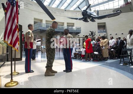 Us Marine Corps Oberstleutnant Joel Schmidt, Operations Officer, Marine Corps Taktik und Operations, präsentiert die Meritorious Service Medal zu Master Sgt. Marcus Gold, Bataillon Operations Chief, SEK BN, an dem Nationalen Museum der Marine Corps, Dreieck, Virginia, 27. Juli 2018. Gold diente 20 Jahre Damen und Gläubigen der Wehrdienst. Stockfoto