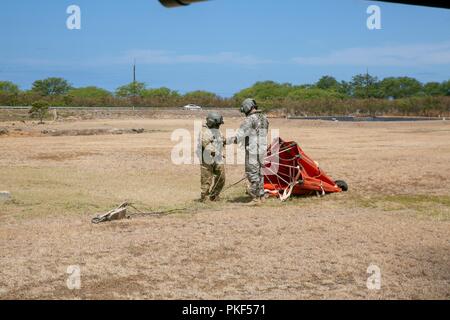 Mannschaft Leiter von 2-25 Aviation Regiment, 25 Combat Aviation Brigade, eine Bambi bucket in Vorbereitung auf die Unterseite einer UH-60 Blackhawk 12.08.6 beifügen. Die Crew unterstützt die Honolulu Feuerwehr und der Abteilung für Forstwirtschaft und Wildlife Feuerwehrmänner zu enthalten und die Mākua Kea'au Forest Reserve wildfire löschen. Stockfoto