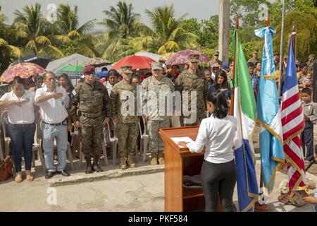 Leiter mit besonderer Zweckbestimmung Marine Air-Ground Task Force - südliche Befehl stehen stramm mit Guatemalteken während der Wiedergabe des in den USA und Guatemala nationalhymnen vor dem Ribbon Cutting und Transfer von Tasten auf einer Baustelle, wo Marines zusammen mit Guatemaltekischen Ingenieure in La Paz, Guatemala, Aug 6, 2018 arbeitete. Die Marinesoldaten und Matrosen von SPMAGTF - SC sind die Zusammenarbeit im Bereich Sicherheit Training und Engineering Projekte Neben partner Nation militärischen Kräfte in Zentral- und Südamerika. Das Gerät ist auch auf Standby humanitäre Hilfe und Katastrophenhilfe zur Verfügung zu stellen Stockfoto