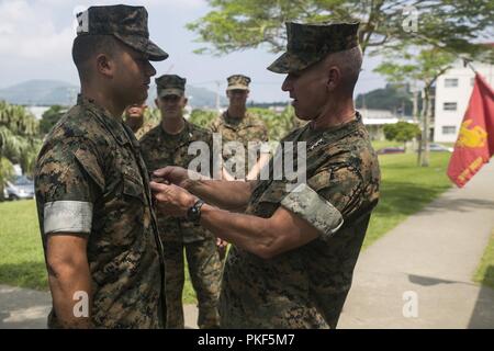 Generalleutnant Eric Smith, III Marine Expeditionary Force kommandierender General, Auszeichnungen Cpl. Samuel Serrano die Navy und Marine Corps Achievement Medal für herausragende Leistung von Aufgaben als Einheit die Bewegung der Koordinator, während einer 31 Marine Expeditionary Unit Besuch im Camp Hansen, Okinawa, Japan, August 8, 2018. Smith besuchten die 31 MEU Marinesoldaten und Matrosen vor einer bevorstehenden Patrouille zu erfüllen. Die 31. MEU, das Marine Corps' nur kontinuierlich vorwärts - bereitgestellt MEU, bietet eine flexible Kraft bereit, ein breites Spektrum an militärischen Operationen in der gesamten indopazifischen Region durchzuführen. Stockfoto