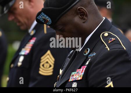 New York Army National Guard Command Sgt. Maj. Anthony Mclean, zu der 27 Infantry Brigade Combat Team zugewiesen, betet während einer Zeremonie im flander's Field amerikanischen Friedhof, Waregem, Belgien, 4. August 2018. Im Rahmen der Gedenkveranstaltungen zum centennial von dem Ende des Ersten Weltkriegs, am 27. und 30 Infantry Brigade Combat Teams schickte Soldaten in Belgien und Frankreich Zeremonien durchzuführen und Tour bekannte Orte, um das Ereignis zu gedenken. Beide Feuerwehren ihre Geschichte verfolgen zu Spaltungen, die im Ersten Weltkrieg kämpfte (N.Y. Army National Guard Stockfoto