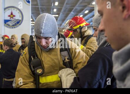 Atlantik (Aug. 6, 2018) Midshipman 2. Klasse Trevor Stutzman, Mitte, von Charlottesville, Virginia, zieht die Brandbekämpfung Ausrüstung während einer General Quarters Bohrers, während Sie an Bord der Flugzeugträger USS George H.W. eingeleitet Bush (CVN 77). Das Schiff ist im Gange, die Durchführung von routinemäßigen Übungen Träger bereit zu halten. Stockfoto