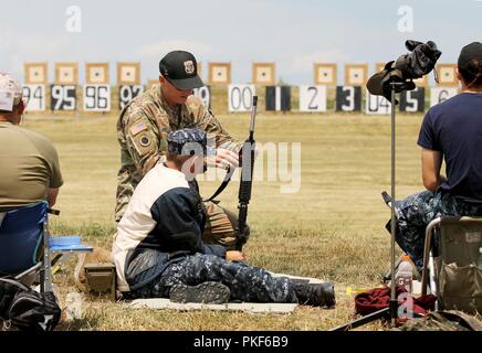 Staff Sgt. Cody Schilde, Zanesville, Ohio gebürtigen und Ausbilder an der US-Armee Treffsicherheit der Einheit Service Rifle Team, unterstützt ein Navy Cadet an die 2018 zivile Treffsicherheit Programme Gewehr Kleinwaffen Feuern Schule 27. Juli im Camp Perry, Ohio. Die jährliche Schule, Sicherheit und verschiedenen Treffsicherheit Techniken umfasst ist Teil der National Rifle entspricht der Zivilen Treffsicherheit und ist offen für aktuelle servicemembers, Veteranen und Zivilisten. Soldaten aus dem USAMU haben den Kurs seit über 30 Jahren unterrichtet. Stockfoto