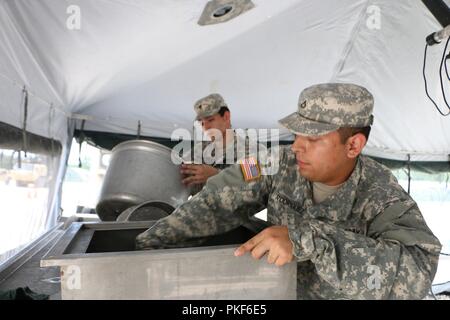U.S. Army Reserve Pfc. Joe Rodriguez und SPC. Edward Herrera, Bereich Abwasserentsorgung Team Mitglieder mit den 370 Transportfirma, in Brownsville, Texas, Waschen, Spülen mit Sitz und sanieren Food Service Equipment, in der Vorbereitung für die USARC 51 Phillip A. Connelly Award Programmevaluierungen, am Lager Bullis, Texas, Aug 3, 2018. Die Phillip A. Connelly Award Programm wurde 1968 gegründet Exzellenz in der Armee Food Service zu erkennen. Das Programm wird gemeinsam von der National Restaurant Association und die Abteilung der Armee gesponsert. Stockfoto