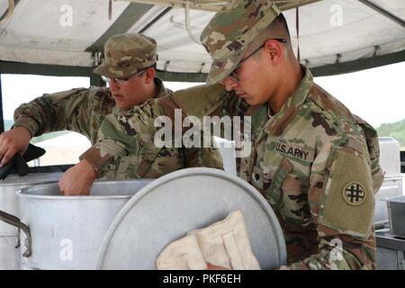 U.S. Army Reserve SPC. Antoni Ramirez und Pfc. Joe-Izaak Castañon, kulinarische Spezialisten, mit dem 370 Transport Unternehmen, Kochen in der Vorbereitung für die USARC 51 Phillip A. Connelly Award Programmevaluierungen, am Lager Bullis, Texas, Aug 3, 2018. Die Phillip A. Connelly Award Programm wurde 1968 gegründet Exzellenz in der Armee Food Service zu erkennen. Das Programm wird gemeinsam von der National Restaurant Association und die Abteilung der Armee gesponsert. Stockfoto