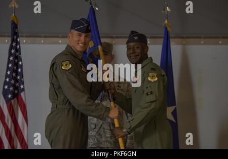 Brig. Gen. Robert Novotny, 57 Wing Commander, übergibt die Guidon zu oberst Travolis Simmons, 57 Gegner Taktik Gruppe eingehenden Commander, die während eines Befehls Preisverleihung auf der Nellis Air Force Base, Nevada, Aug 3, 2018. Der 57 ATG besteht aus sieben Staffeln, darunter drei geographisch getrennte Einheiten. Stockfoto