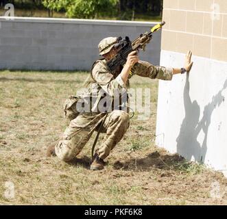 Ein Soldat aus dem 3 Prince of Wales Royal Regiment klammern gegen eine Wand während einer Praxis Ausführen ihrer Verletzung und klare Abläufe August 8, 2018, Camp Äsche, MI. Die 3 PWRR ist in Northern Strike 18 Teilnehmenden, ein National Guard Bureau - geförderte Übung vereint Service Mitglieder aus vielen Staaten, mehrere Filialen und eine Reihe von Koalition Ländern während der ersten drei Wochen im August 2018 im Camp Äsche gemeinsame Manöver Training Center und die alpena Combat Readiness Training Center, beide im nördlichen Michigan gelegen und durch die Michigan National Guard betrieben. (Michi Stockfoto