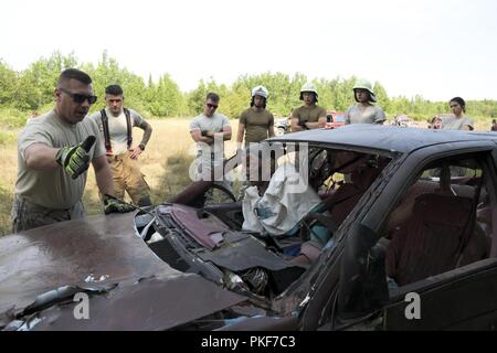 Lettische Feuerwehrmänner erhalten eine Ausbildung als Ersthelfer und Rettung aus verunfallten Fahrzeugen an der Carmeuse Calcit Steinbruch, Rogers City, Michigan, während Northern Strike 18 Aug 8, 2018. Northern Strike18 ist ein National Guard Bureau - geförderte Übung vereint Service Mitglieder aus vielen Staaten, mehrere Filialen und eine Reihe von Koalition Ländern während der ersten drei Wochen im August 2018 im Camp Äsche gemeinsame Manöver Training Center und die alpena Combat Readiness Training Center, beide im nördlichen Michigan gelegen und durch die Michigan National Guard betrieben. Die akkreditierte Gemeinsame Nation Stockfoto
