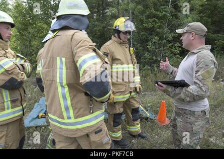 Lettische Feuerwehrmänner erhalten eine Ausbildung als Ersthelfer und Rettung aus verunfallten Fahrzeugen an der Carmeuse Calcit Steinbruch, Rogers City, Michigan, während Northern Strike 18 Aug 8, 2018. Northern Strike18 ist ein National Guard Bureau - geförderte Übung vereint Service Mitglieder aus vielen Staaten, mehrere Filialen und eine Reihe von Koalition Ländern während der ersten drei Wochen im August 2018 im Camp Äsche gemeinsame Manöver Training Center und die alpena Combat Readiness Training Center, beide im nördlichen Michigan gelegen und durch die Michigan National Guard betrieben. Die akkreditierte Gemeinsame Nation Stockfoto