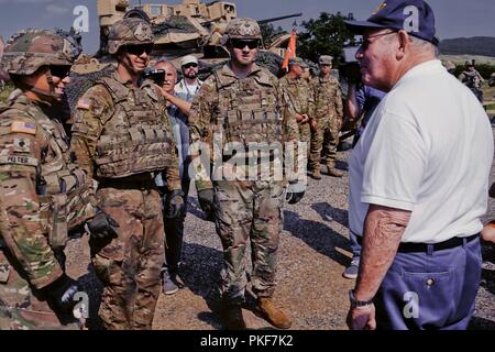 Us-Botschafter in Ungarn David B. Cornstein mit Spc erfüllt. Patrick J. Peltier (links), U.S. Army Pvt. Jakob L. Beier (Mitte) und der US-Army Staff Sgt. Alex J. Marston (rechts), die indirekte Feuer Infanteristen von Comanche Truppe, 1st Squadron, 7th Cavalry Regiment, 1st Armored Brigade Combat Team, 1.Kavallerie Division während einer betrieblichen Ausbildung Beobachtungstag im zentralen Bereich Schulungen in Várpalota, Ungarn, Aug 3, 2018. Comanche Truppe Cornstein eingeladen, Bürgermeister aus den Städten rund um den Bereich Schulungen, ungarische Soldaten und lokalen ungarischen Medien Static Display zu sehen und Demonstrationen o Stockfoto