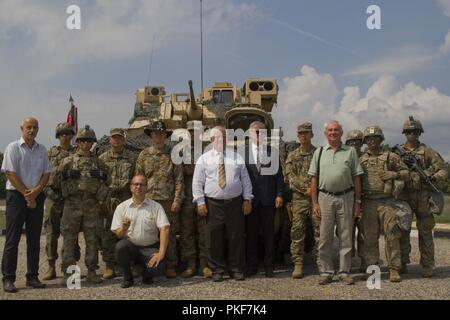 Comanche Truppe, 1st Squadron, 7th Cavalry Regiment, 1st Armored Brigade Combat Team, 1.Kavallerie Division, und Bürgermeister aus den umliegenden Städten posieren vor einem M3 Bradley Fighting Fahrzeug während einer betrieblichen Ausbildung Beobachtungstag im zentralen Bereich Schulungen in Várpalota, Ungarn, Aug 3, 2018. Comanche Truppe eingeladen, der US-Botschafter in Ungarn David B. Cornstein, Bürgermeister aus den Städten rund um den Bereich Schulungen, ungarische Soldaten und lokalen ungarischen Medien Statische Displays und Demonstrationen von Fahrzeugen, Waffen, Ausrüstung und Fähigkeiten zu sehen. Stockfoto