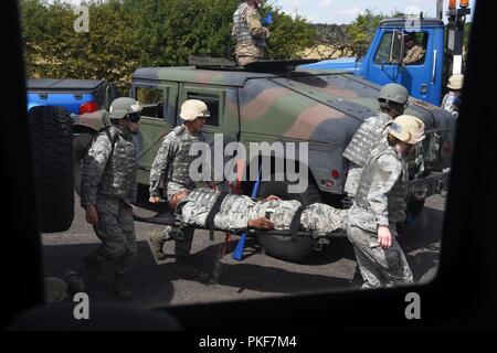 Fahrzeuge Flieger auf der 48th Fighter Wing und 100 Luftbetankung Flügel Transport simuliert aus einem Humvee zu einem simulierten Rettungshubschrauber Landing Zone an der Stanford, Suffolk, England, August 04, 2018 verwundet zugeordnet. Während die selbst Hilfe und Buddy Care (SABC) Ausbildung Abschnitt, Fahrzeuge Flieger auf, wie man einen Stauschlauch an sich selbst und anderen anzuwenden, wie Bahre verwundet tragen ausgebildet wurden, wie man Stammzellen Stichwunden und wie die HLW durchzuführen. Stockfoto