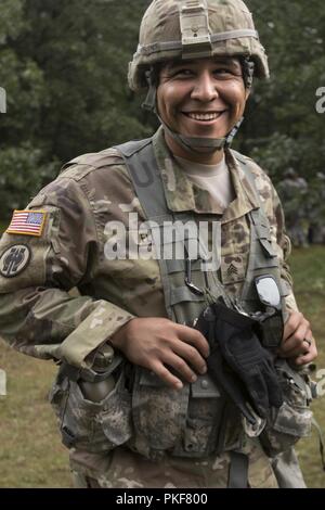 Sgt. Raul Flores, ein US Army Reserve Militärpolizei Soldat der 324 Militärpolizei Firma zugewiesen, posiert für ein Foto zwischen Lethal warrior Skills Training Bahnen im Rahmen der Operation Blue Shield Aug 7, 2018 at Fort McCoy, Wisconsin. Betrieb Blue Shield ist ein funktionelles Training, in 2-Wochen Zyklen gebrochen, auf Gruppe und Team zentriert Ausbildung mit einem Schwerpunkt auf der Internierung, Umsiedlung, häftling Operationen und unterstützen. Während der jeweils 2-wöchigen Zyklus, Lote Zug auf internierung Operationen, Waffen Qualifikation, Biometrie, reflexive Feuer, und militärische Operationen auf Urbani Stockfoto