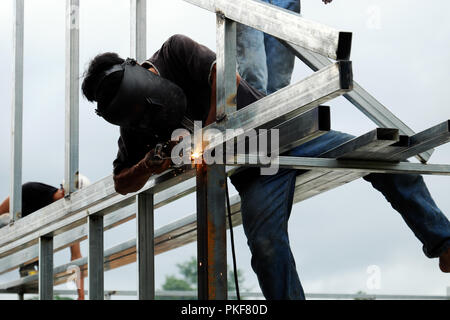 Asiatischer mann Schweißer klettern auf Stahlrahmen und Schweißen von Stahl Haus in Ho Chi Minh City, Vietnam Stockfoto