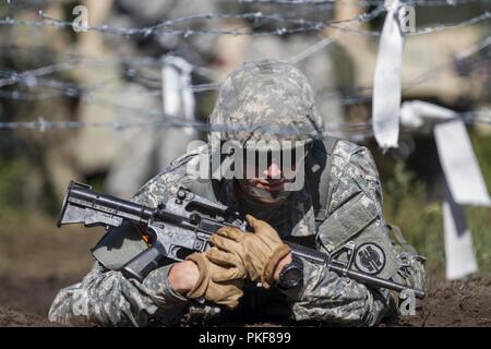 Ein U.S. Army Reserve Soldat mit dem 302Nd Military Police Company kriecht unter Stacheldraht während tödliche Krieger Training am Fort McCoy, Wisconsin, am Aug 8, 2018. Stockfoto