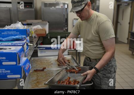 Staff Sgt. Lucas Buike, der Assistant Restaurant Manager mit dem 155 Force Support Squadron, bereitet Speck zum Frühstück Aug 8, 2017, in der Army National Guard Greenlief Training Website, in der Nähe von Hastings, Nebraska. Stockfoto