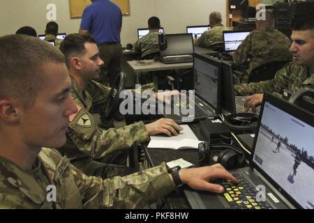 Armee Reservisten, von links, SPC. Nicholas Klein, Sgt. Vincent Floyd und Sgt. Andrew Mercado, mit der 353 Transportunternehmen aus Buffalo, Minnesota Praxis Konvoi Operationen auf einem Virtual battlespace Simulator auf Fort McCoy, Wisconsin 12.08.7. Stockfoto