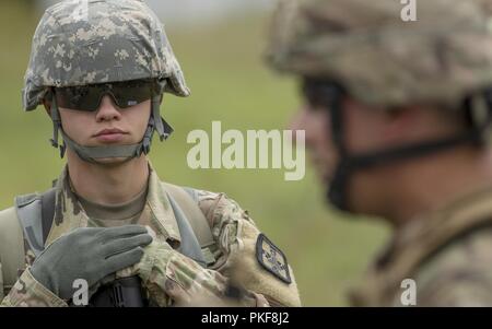 Ein U.S. Army Reserve Soldaten des 801St Combat Support Hospital hört Staff Sgt. Joshua Guthrie verhalten Lethal warrior Training als Teil der globalen Medic 2018 auf Fort McCoy, Wisconsin, Aug 7, 2018. Global Medic ist ein Training konzipiert, um sicherzustellen, dass die Armee finden Medical Command (ARMEDCOM) bietet geschult, fähig und bereit, Kampf Einheiten in der Armee und der gemeinsamen Kraft. Stockfoto