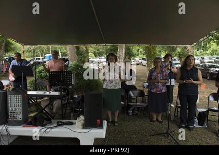 Die "Unserer Lieben Frau von Lourdes' Erbe Chor singt während der Messe vor dem Massaker Chaguian Gedenkfeier am 8. August 2018, in Yigo, Guam. Die Zeremonie ist jedes Jahr beobachtet, um die Erinnerung an die Chamorro Männer, die ihr Leben in der Massaker verloren zu ehren. Stockfoto