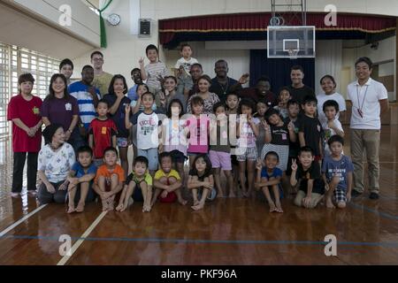 Marinesoldaten und Matrosen mit Combat Logistik Bataillon 31, 31 Marine Expeditionary Unit, für ein Gruppenfoto mit einheimischen Kindern an Namisato Community Center, Okinawa, Japan, August 9, 2018 darstellen. Community Relations Veranstaltungen geben 31. MEU Marines eine Gelegenheit, um die Beziehungen zu den Nachbarn aufzubauen und einen Beitrag zu den Gemeinschaften um Marine Corps Installationen. Stockfoto