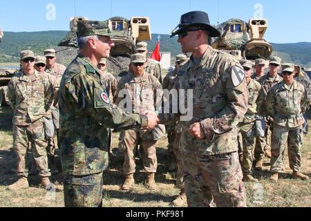 Us-Armee Kapitän Nicholas Spicocchi, Kommandeur der Alpha Company, 2nd Battalion, 5th Cavalry Regiment, 1st Armored Brigade Combat Team, 1.Kavallerie Division, gibt Bulgarische Col. Stojan Georgiev Schopow, 2. mechanisierten Brigade Stabschef, eine Münze als Zeichen der Anerkennung bei der Abschlussfeier der Übung Platin Löwe, eine jährliche Übung, fördert die regionale Stabilität und baut dauerhafte Beziehungen mit Partnerstaaten, bei der Abschlussfeier, Novo Selo, Bulgarien, 9. August 2018. Diese Übung ist zur Unterstützung der Atlantischen lösen, ein bleibendes Training bet Stockfoto