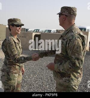 Generalleutnant Timothy J. Kadavy, Direktor der U.S. Army National Guard, stellt Oberst Kimberly M. Martindale, Kommandant der 38th Sustainment Brigade, mit seiner National Guard Münze nach seinem Besuch in der Brigade im Camp Arifjan, Kuwait, am 10. August. Stockfoto