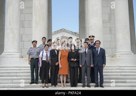 Ein Gruppenfoto mit Südkorea Minister von Patrioten und Veterans Affairs Pi Woo-Jin (Mitte rechts), Südkorea Stellvertretender Minister für Nationale Verteidigung Lee Nam-Woo (ganz rechts) und Katharine Kelley (Mitte links), Betriebsleiter, Arlington National Cemetery, im Westen die Schritte des Memorial Amphitheater auf dem Arlington National Cemetery, Arlington, Virginia, 8. August 2018. Nam-Woo Woo-Jin und legte einen Kranz am Grab des Unbekannten Soldaten und das Denkmal Amphitheater Anzeige Zimmer tourte im Rahmen ihres Besuches in ANC. Beide wurden in Washington, D.C. die Verteidigung POW/MIA Accounting Agentur (DP zu besuchen Stockfoto