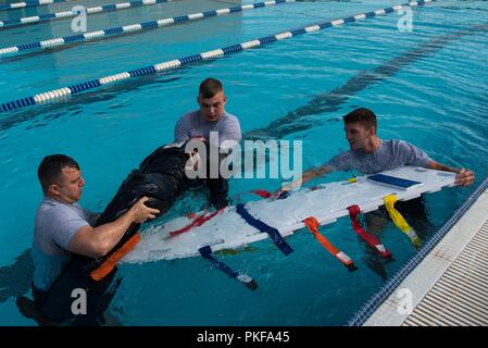 Emergency Medical Technician Rodeo Teilnehmer ziehen einer trainingspuppe aus einem Pool an Cannon Air Force Base, N.M., Aug 8, 2018. Der EMT-Rodeo bietet Technikern mit einer Vielzahl von Szenarien, die ihre Kenntnisse und Fähigkeiten in Notsituationen zu testen. Stockfoto