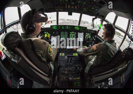 Us Air Force Oberstleutnant Patrick McBride, Links, und Maj. Nick Kim, rechts, sowohl des 146. Airlift Wing, California Air National Guard, sitzen im Cockpit des MAFFS 4, ein modulares System zur Brandbekämpfung aus der Luft Hercules C-130 Flugzeugen aus den 146 th ausgestattet, während ein Anschlag mit Feuerhemmenden an der U.S. Forest Service San Bernardino Airtanker Base zu laden, in San Bernardino, Kalifornien, Aug 8, 2018. MAFFS 4 flog staatliche Agenturen kämpfen das heilige Feuer in Orange und Riverside Grafschaften zu unterstützen. Stockfoto