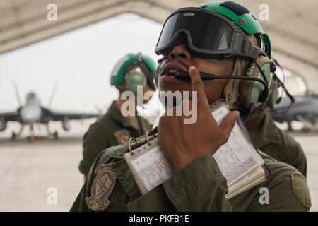 Unbekannten ORT, Südwesten Asien - US Marine Corps Cpl. Jeffery Fitzpatrick, einer Luftfahrt Elektronik Techniker mit Marine Fighter Attack Squadron 115, Marine Flugzeuge Gruppe 31, 2. Marine Flugzeugflügel, spricht mit der Pilot einer F/A-18 Hornet. Die Marines kontinuierlich führen Wartungsarbeiten am Flugzeug an die Einheit zugeordnet zu halten für Close Air Support für den speziellen Zweck Marine Air-Ground Task Force, Krise Response-Central Befehl vorbereiten und. Stockfoto