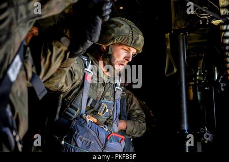 Eine polnische militärische Fallschirmjäger blickt über Polen, wie er sich vorbereitet von der US Air Force C-130J Hercules Super August 7, 2018 zu springen. Zwei C-130 Js 86th Airlift Wing zugeordnet airdropped ca. 100 polnische Truppen als Teil einer jährlichen bilateralen Übung mit der polnischen Armee. Stockfoto