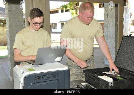 Us Air Force Staff Sgt. Christopher Chase und Senior Airman Derrick Langlais, cyber Systeme Betreiber die 158 Fighter Wing, Vermont Air National Guard zugeordnet, die Kommunikation in der Community Center in Molokai, Hawaii für Tropic Care für Maui County 2018 August 11, 2018. Tropic Care Maui County 2018 ist eine gemeinsame - Service Innovative Readiness Training Mission von der Air National Guard geführt und durch Mitglieder der Luftwaffe, Heer, Marine Reserve unterstützt, und Marine Corps finden. Gesundheit Kliniken an Zentralen Maui, Kihei, Lahaina, Hana, Molokai und Lanai ist ab August 11-19, Anbietern Stockfoto