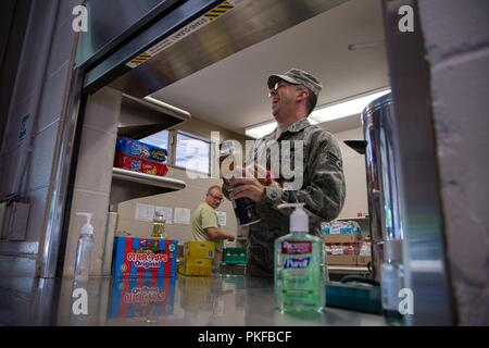 Us Air Force Staff Sgt. Nick Hochmuth, eine Küche Aufsichtsplatz, zu der 109 Airlift Wing, New York Air National Guard zugeordnet, reagiert auf ein Witz von einem anderen Flieger an der Mitchell Pauole Community Center in Molokai, Hi, August 11, 2018. Tropic Care Maui County 2018 bietet medizinische Truppen und den Support "hands-on"-Readiness Training für zukünftige Bereitstellungen vorbereiten, während für direkte und dauerhafte Vorteile für die Bevölkerung von Maui, Molokai und Lanai. Stockfoto
